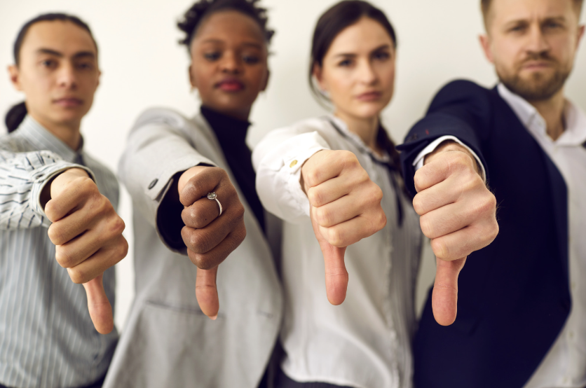 four people giving a thumbs down